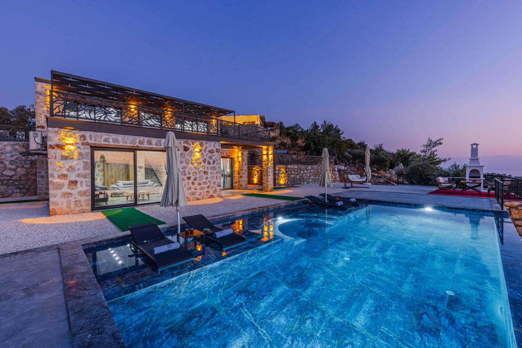 Villa Alazán's stone-clad facade and pool terrace in late-afternoon light, Golden Mile, Marbella